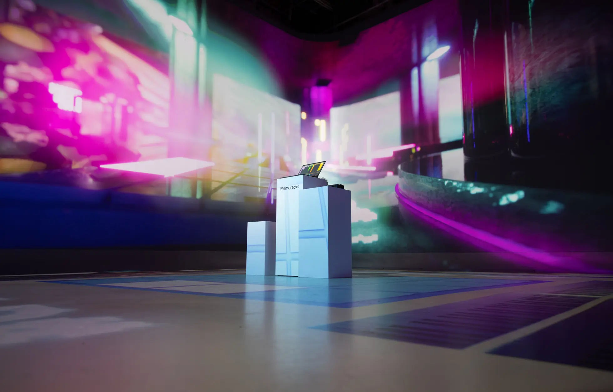 Une installation d'art numérique futuriste et colorée avec un podium et un éclairage vibrant.