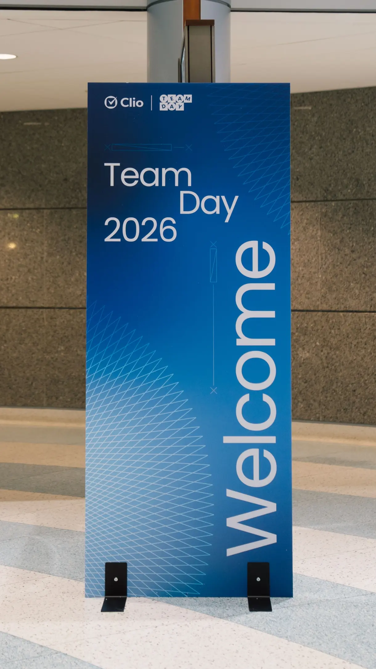 Un panneau bleu avec "Team Day 2026" et "Welcome" en texte blanc.
