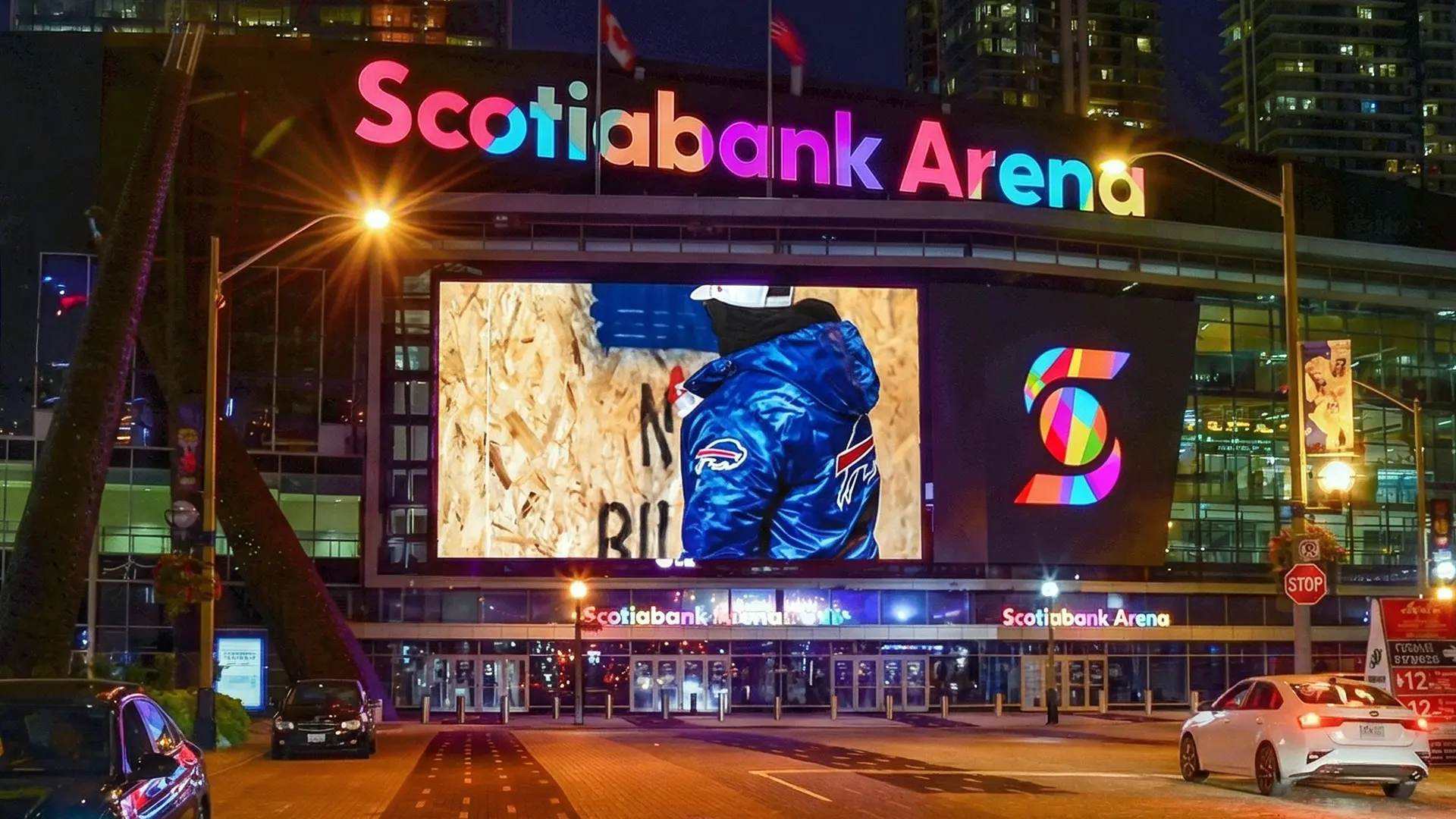 Entrée principale de la Scotiabank Arena la nuit avec une signalétique illuminée et un grand écran vidéo.