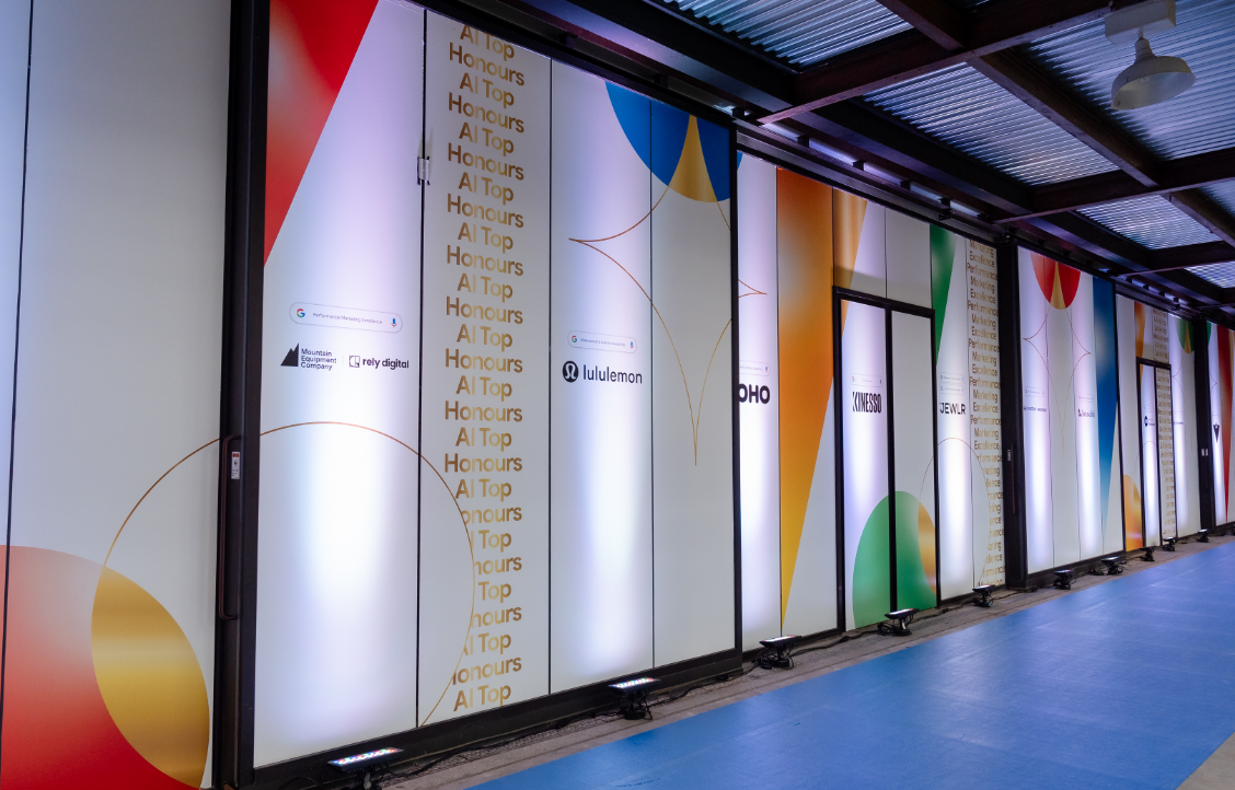 Un couloir intérieur avec des designs géométriques colorés et des logos sur les murs.