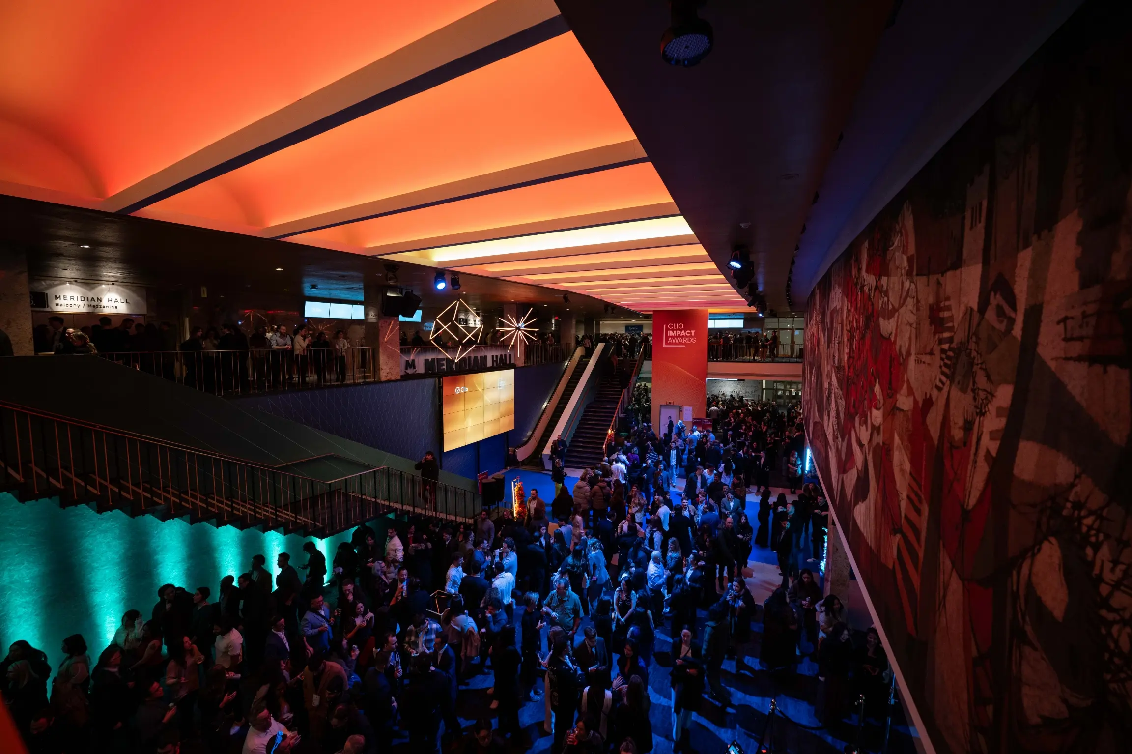 A large crowd gathers in the brightly lit interior of Meridian Hall during an event.