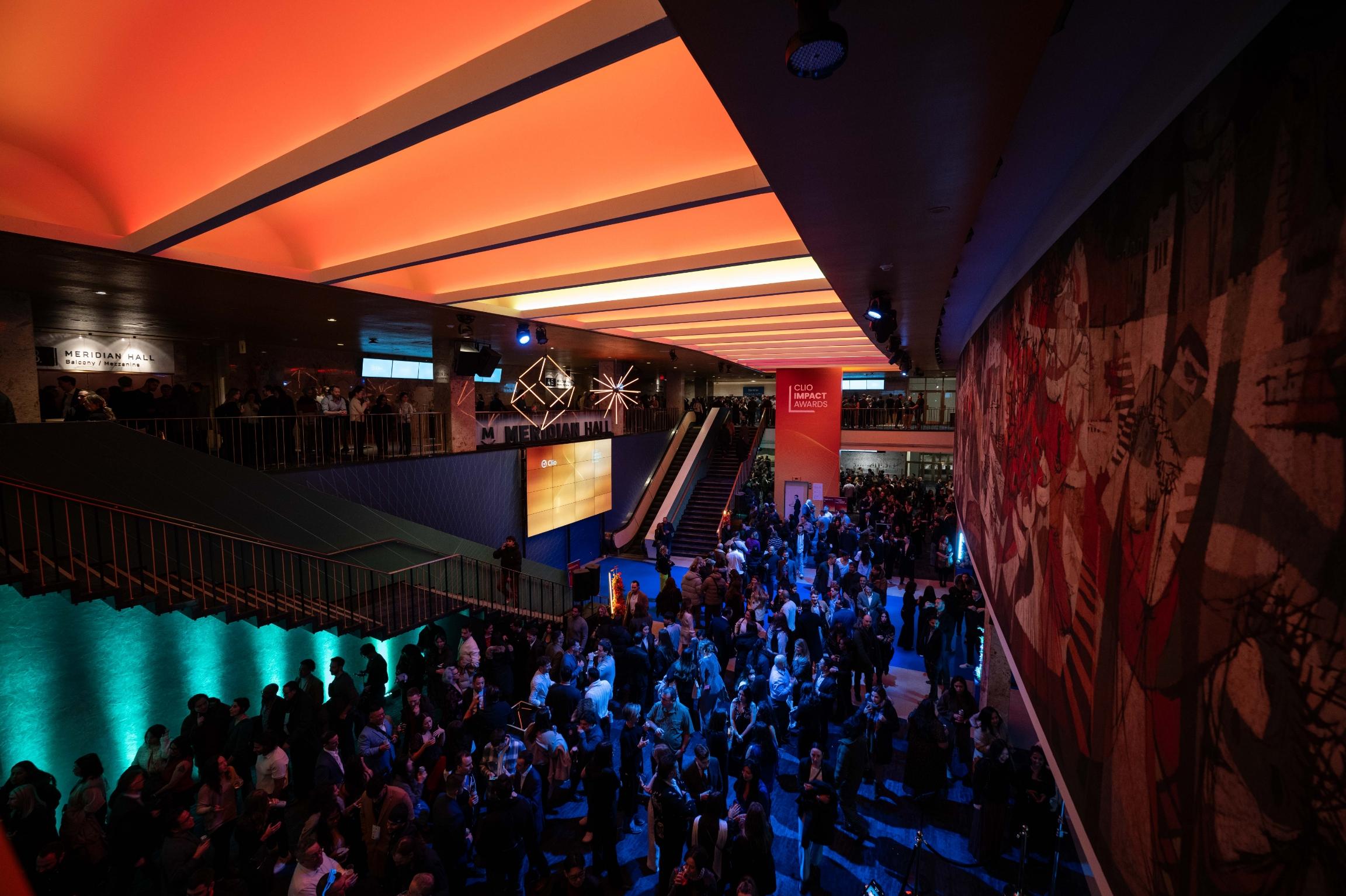 Une grande foule se rassemble dans l'intérieur vivement éclairé de Meridian Hall lors d'un événement.