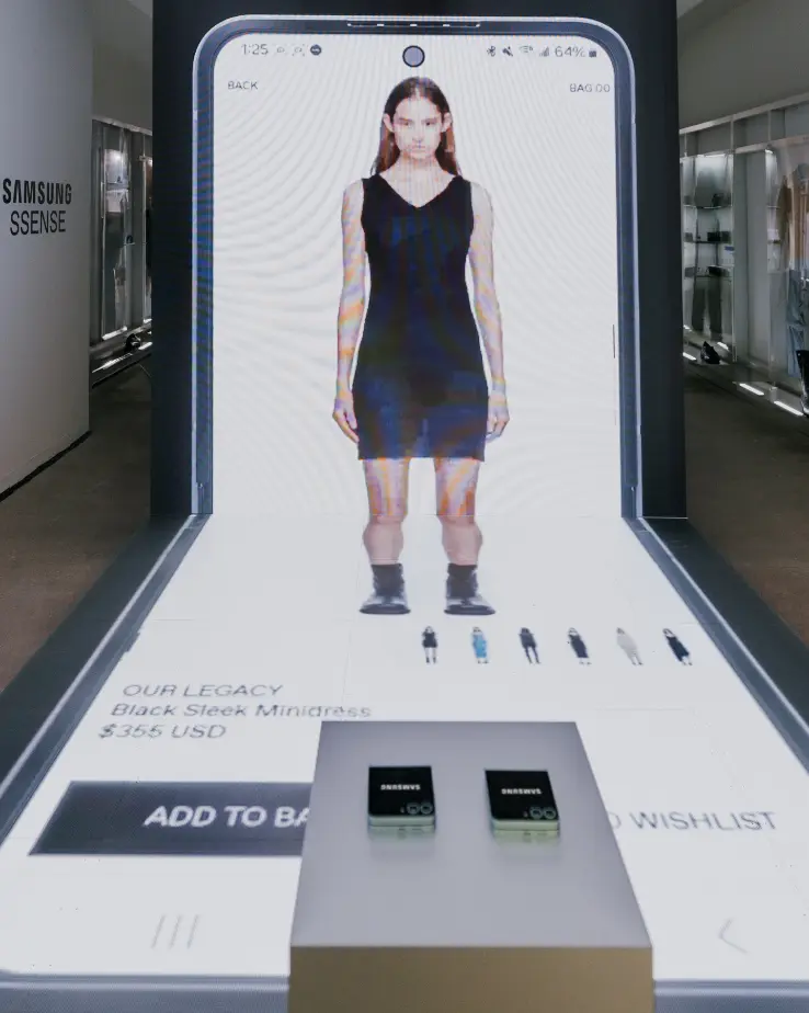 Un grand écran numérique montre une femme portant une mini-robe noire avec des options d'achat en dessous.