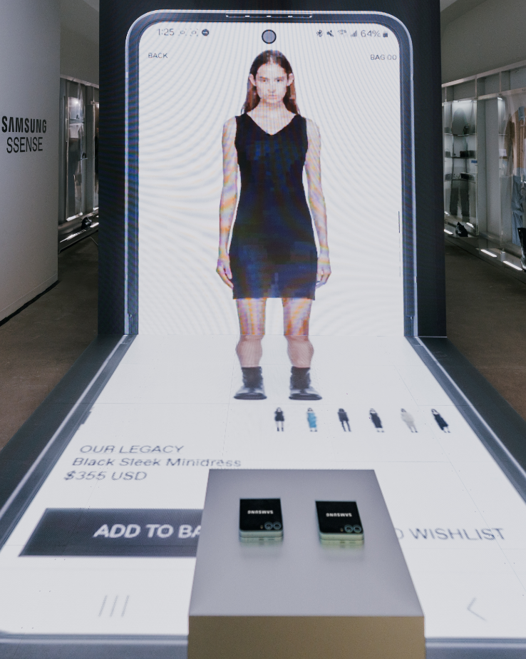 Un grand écran numérique montre une femme portant une mini-robe noire avec des options d'achat en dessous.