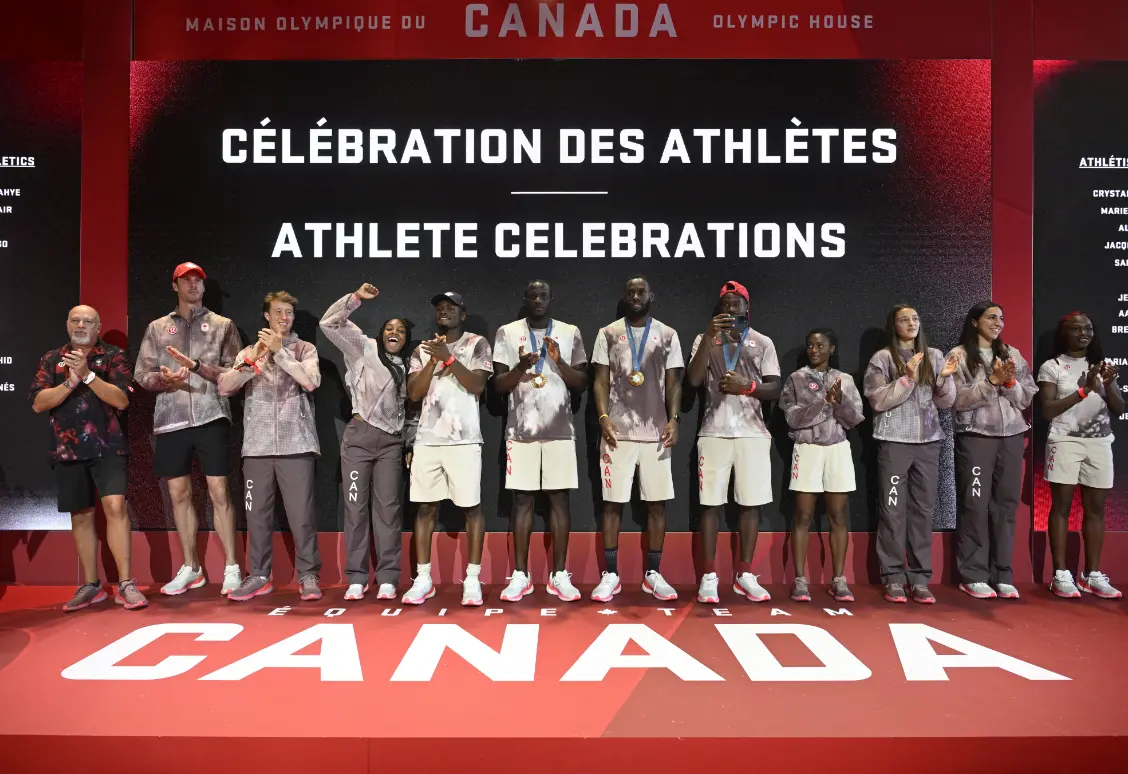 Un groupe d'athlètes sur scène lors d'un événement célébrant leurs réalisations, avec un fond affichant « Célébrations d'athlètes » en anglais et en français.