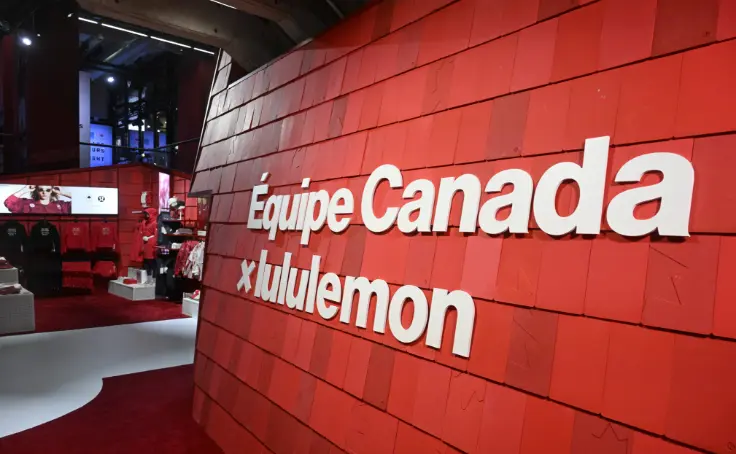 Mur rouge avec texte blanc indiquant « Équipe Canada x lululemon » dans un présentoir de magasin.